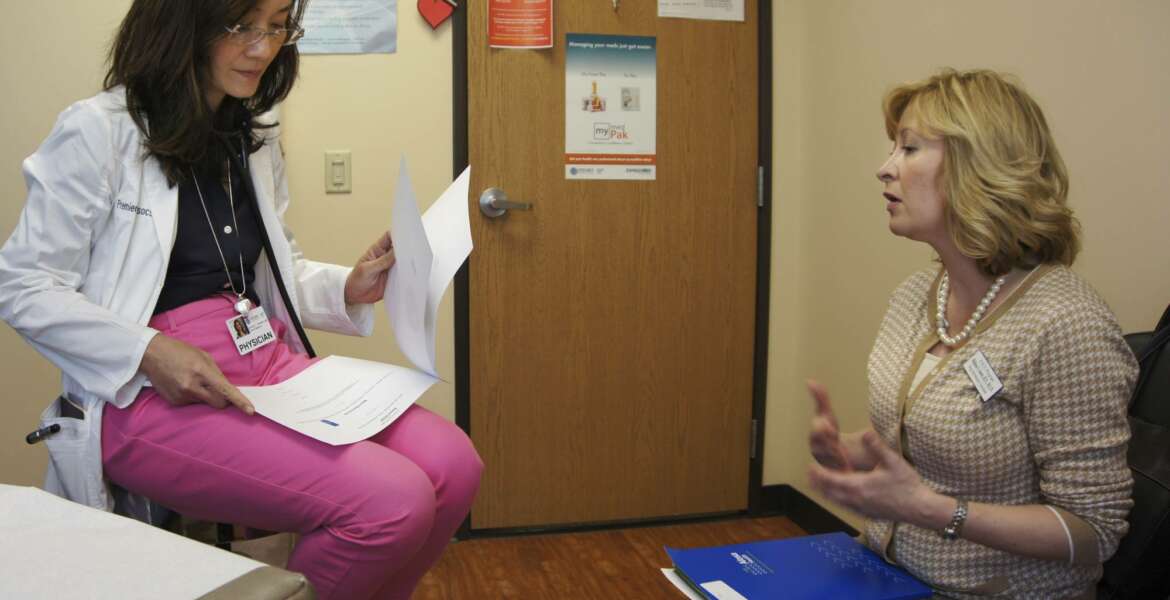 In this May 4, 2017 photo, Melissa Jones, right, a nurse educator with Alosa Health, speaks with Dr. Dorothy Wilhelm in an exam room at a medical office in Monroeville, Pa. Jones visits medical offices in western Pennsylvania to educate doctors about new opioid prescribing guidelines. (AP Photo/Carla K. Johnson)