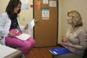 In this May 4, 2017 photo, Melissa Jones, right, a nurse educator with Alosa Health, speaks with Dr. Dorothy Wilhelm in an exam room at a medical office in Monroeville, Pa. Jones visits medical offices in western Pennsylvania to educate doctors about new opioid prescribing guidelines. (AP Photo/Carla K. Johnson)