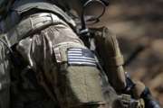 In this photo taken Friday, April 21, 2017 a United States flag patch adorns the uniform of a paratrooper with the 82nd Airborne Division's 3rd Brigade Combat Team during a training exercise at Fort Bragg, N.C. The Army is planning to triple the amount of bonuses it’s paying this year to more than $380 million in a bid to expand its ranks. The money includes new incentives to woo reluctant soldiers to re-enlist.  (AP Photo/Gerry Broome)