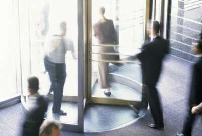 High angle view of business executives walking through a revolving door
