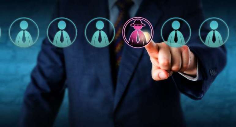 Corporate security manager identifies a potential insider threat in a line-up of eight white collar workers. Hacker or spy icon lights up purple. Cybersecurity and human resources challenge concept.