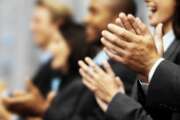 Side profile of a group of young executives clapping (blurred)