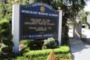 FILE - In this Sept. 13, 2016, file photo, a sign welcomes visitors at the entrance to the U.S. Merchant Marine Academy in Kings Point, N.Y. Seven suspended men's soccer players at the U.S. Merchant Marine Academy will face campus disciplinary hearings over allegations of sexual misconduct, coercion and hazing, according to a federal lawyer. Newsday reported on July 22, 2017, that Assistant U.S. Attorney James H. Knapp said the students were sexually abusive toward a freshman player on the team bus in September 2-17, and they squirted water or urine plus covered several people with food, (AP Photo/Frank Eltman, File)