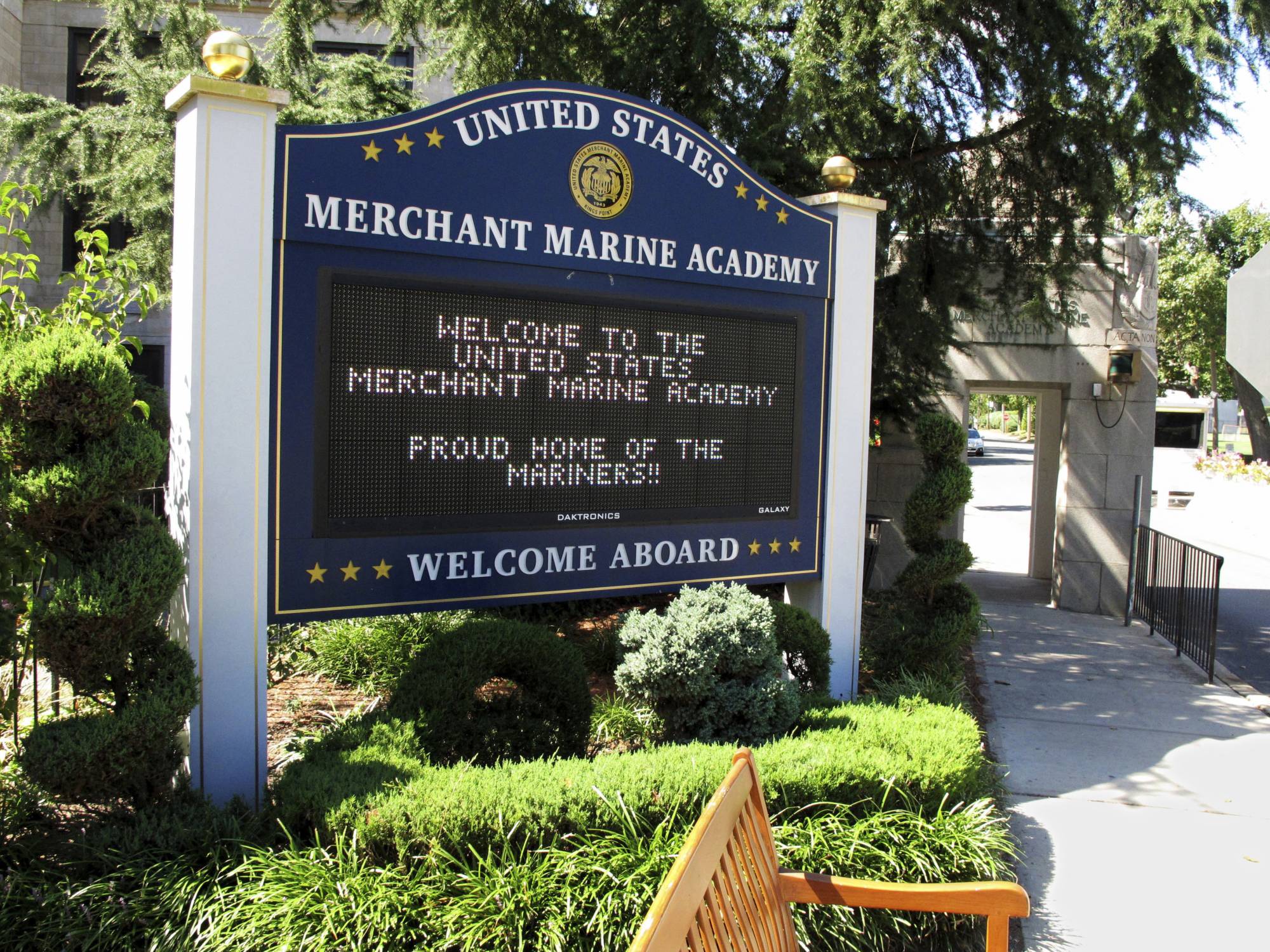 FILE - In this Sept. 13, 2016, file photo, a sign welcomes visitors at the entrance to the U.S. Merchant Marine Academy in Kings Point, N.Y. Seven suspended men's soccer players at the U.S. Merchant Marine Academy will face campus disciplinary hearings over allegations of sexual misconduct, coercion and hazing, according to a federal lawyer. Newsday reported on July 22, 2017, that Assistant U.S. Attorney James H. Knapp said the students were sexually abusive toward a freshman player on the team bus in September 2-17, and they squirted water or urine plus covered several people with food, (AP Photo/Frank Eltman, File)