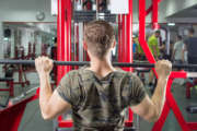 Muscular man performing lat pulldown at the gym