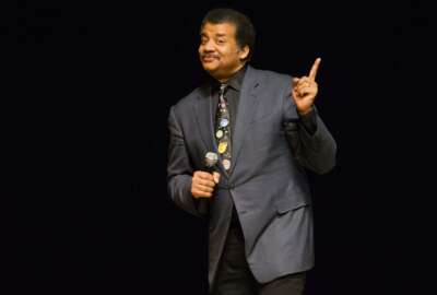 FILE - In this March 21, 2017 file photo, astrophysicist Neil deGrasse Tyson presents a lecture at the Morris Performing Arts Center in South Bend, Ind. Tyson has a suggestion for anyone with a view of next week's solar eclipse: Put down your smartphone and take in the phenomenon yourself. Tyson told an audience to 
