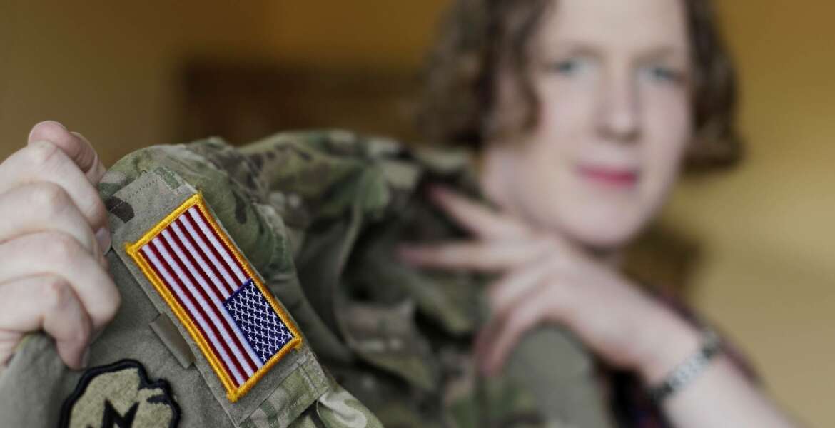 In this July 29, 2017 photo transgender U.S. army captain Jennifer Sims lifts her uniform during an interview with The Associated Press in Beratzhausen near Regensburg, Germany. (AP Photo/Matthias Schrader)