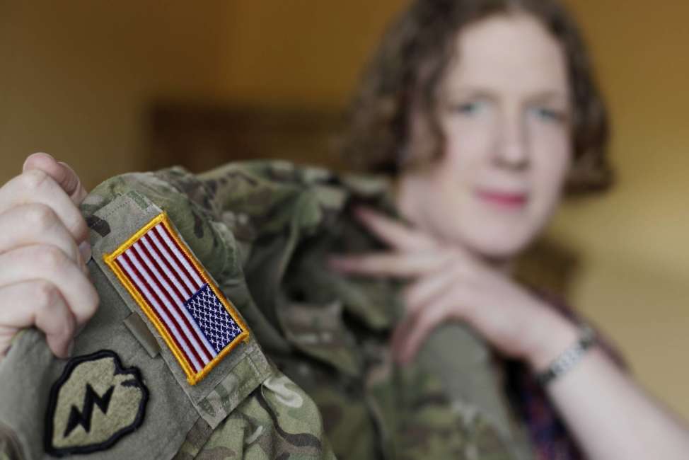 In this July 29, 2017 photo transgender U.S. army captain Jennifer Sims lifts her uniform during an interview with The Associated Press in Beratzhausen near Regensburg, Germany. (AP Photo/Matthias Schrader)