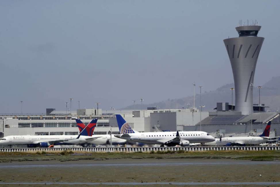 FILE - In this July 11, 2017 file photo, departing and parked aircraft intersect at San Francisco International Airport in San Francisco. Federal officials are imposing new rules on nighttime landings at San Francisco airport after a close call last month. The FAA will also require 2 controllers in the tower. The changes come after an Air Canada jet narrowly missed planes on the ground before aborted an off-line landing on July 7, 2017. (AP Photo/Marcio Jose Sanchez, File)