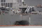 In this Tuesday, Aug. 22, 2017, filephoto, the damaged port aft hull of the USS John S. McCain, is visible while docked at Singapore's Changi naval base in Singapore. The focus of the search for the U.S. sailors missing after a collision between the USS John S. McCain and an oil tanker in Southeast Asian waters shifted Tuesday to the damaged destroyer's flooded compartments. (AP Photo/Wong Maye-E, File)