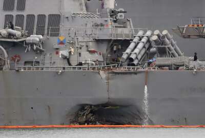 FILE - In this Aug. 22, 2017 file photo. the damaged port aft hull of the USS John S. McCain is visible while docked at Singapore's Changi naval base in Singapore. The wrenching deaths of sailors, drowned while trapped in their bunks on the USS John S. McCain has reverberated around the American fleet.  (AP Photo/Wong Maye-E, File)