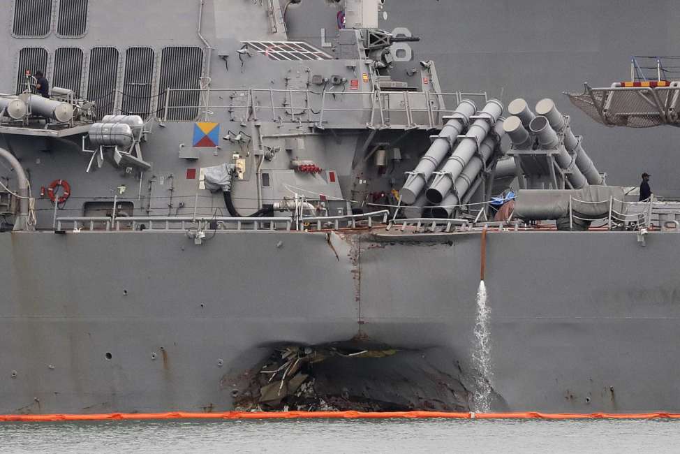 FILE - In this Aug. 22, 2017 file photo. the damaged port aft hull of the USS John S. McCain is visible while docked at Singapore's Changi naval base in Singapore. The wrenching deaths of sailors, drowned while trapped in their bunks on the USS John S. McCain has reverberated around the American fleet.  (AP Photo/Wong Maye-E, File)