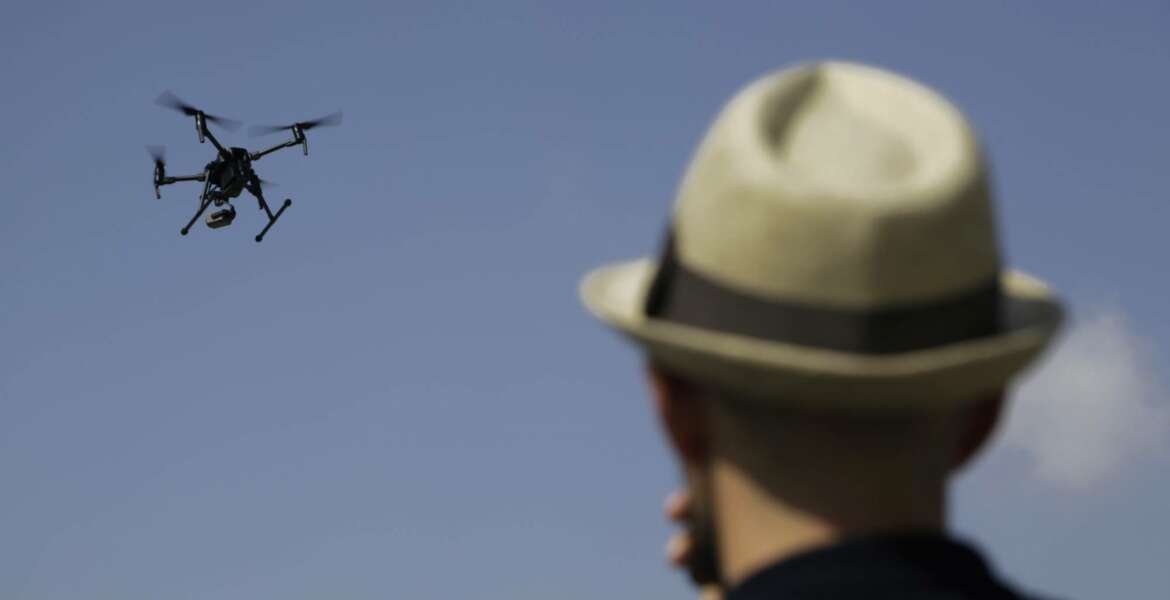 A man watches a drone during a demonstration at the British police station inside the British military base in Dhekelia in southeast of the island of Cyprus, Thursday, Sept. 21, 2017. Police at Britain's two military bases on Cyprus say the use of a state-of-the-art drone will greatly boost their ongoing crackdown on the illicit trapping of migratory birds. (AP Photo/Petros Karadjias)