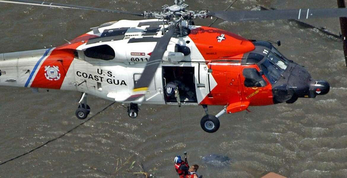 FILE - In this Tuesday, Aug. 30, 2005 picture, a New Orleans resident is rescued from the rooftop of a home by a U.S. Coast Guard helicopter crew as floodwaters from Hurricane Katrina cover the streets. (AP Photo/David J. Phillip)