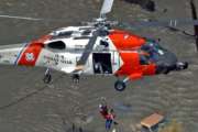 FILE - In this Tuesday, Aug. 30, 2005 picture, a New Orleans resident is rescued from the rooftop of a home by a U.S. Coast Guard helicopter crew as floodwaters from Hurricane Katrina cover the streets. (AP Photo/David J. Phillip)