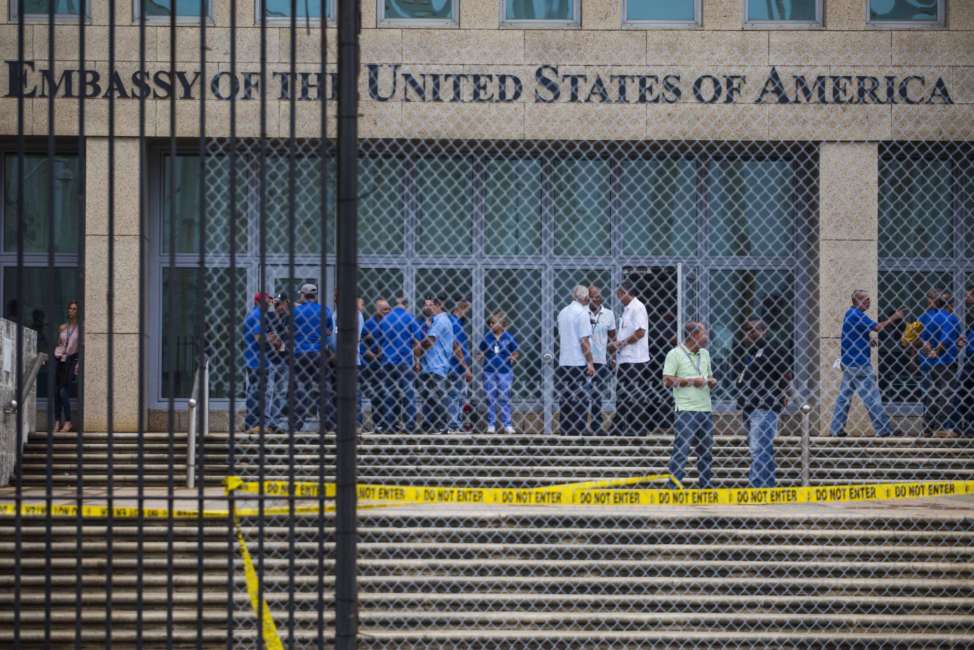 FILE - In a Friday, Sept. 29, 2017 file photo, staff stand within the United States embassy facility in Havana, Cuba. The terrifying attacks in Cuba overwhelmingly hit U.S. intelligence operatives in Havana, not ordinary diplomats, when they began within days of President Donald Trump’s election, The Associated Press has learned.  To date, the Trump administration largely described the victims as U.S. Embassy personnel or “members of the diplomatic community,” suggesting it was bona fide diplomats who were hit. That spies, working under diplomatic cover, comprised the majority of the early victims adds an entirely new element of mystery to what’s harmed at least 21 Americans over the last year.  (AP Photo/Desmond Boylan, File)