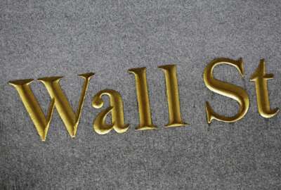 FILE - This Monday, July 6, 2015, file photo shows a sign for Wall Street carved into the side of a building in New York. Stock markets around the world took a pause on Monday, Oct. 30, 2017, from their record-setting run ahead of a busy week for markets. (AP Photo/Mark Lennihan, File)