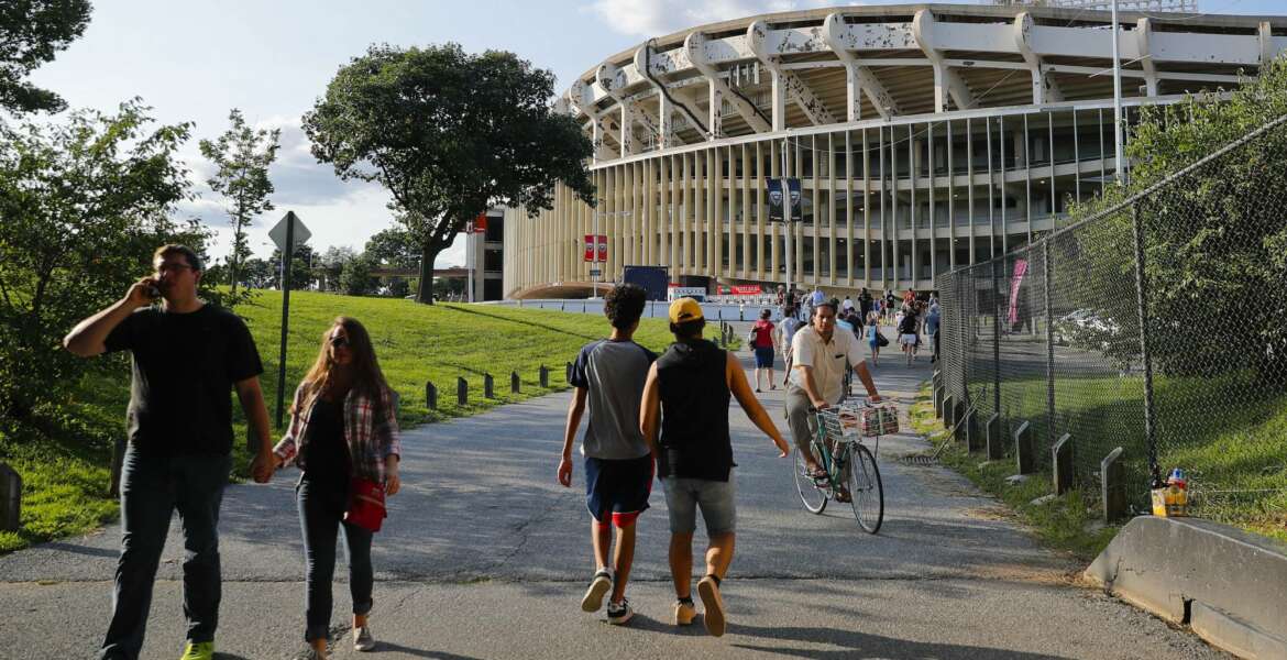 FILE - In this Aug. 5, 2017, file photo, people make their way to RFK Stadium in Washington before the start of an MLS soccer match between D.C. United and Toronto FC.  D.C. United will play their final game at RFK Stadium on Sunday. The United have already been eliminated from the playoffs, but they hope to say goodbye to the historic venue with a victory over the Red Bulls. (AP Photo/Pablo Martinez Monsivais, File)