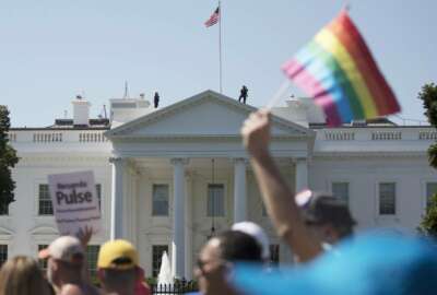 FILE - In this Sunday, June 11, 2017 file photo, Equality March for Unity and Pride participants march past the White House in Washington. A federal court in Washington is barring President Donald Trump from changing the government's policy on military service by transgender people.  (AP Photo/Carolyn Kaster)