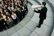 Businessman Standing on Steps Outside Talking Through a Megaphone, Large Group of Business People Listening and Applauding