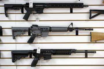 A Ruger AR-15 semi-automatic rifle, center, the same model, though in gray rather than black, used by the shooter in a Texas church massacre two days earlier, sits on display with other rifles on a wall in a gun shop Tuesday, Nov. 7, 2017, in Lynnwood, Wash. Gun-rights supporters have seized on the Texas church massacre as proof of the well-worn saying that the best answer to a bad guy with a gun is a good guy with a gun. Gun-control advocates, meanwhile, say the tragedy shows once more that it is too easy to get a weapon in the U.S. (AP Photo/Elaine Thompson)