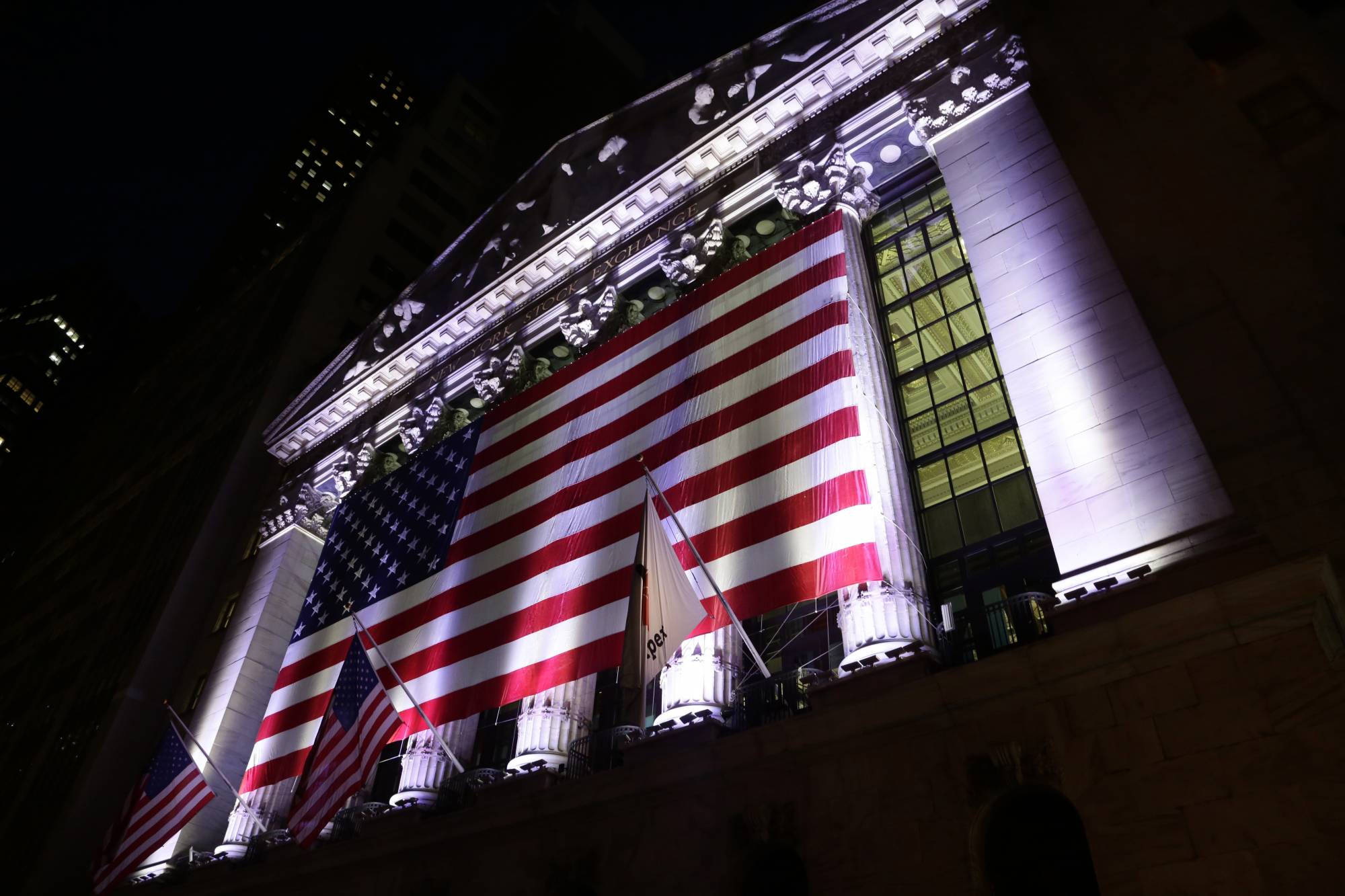FILE - In this Friday, Feb. 17, 2017, file photo, an American flag hangs on the front of the New York Stock Exchange. U.S. stock indexes edged higher in early trading Monday, Nov. 27, as traders returned from the Thanksgiving holiday. Banks and retailers were among the big gainers. Energy stocks lagged the most as crude oil prices headed lower. Several companies were also moving on deal news. (AP Photo/Peter Morgan, File)