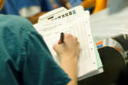 Surgical nurse writing on patient chart.