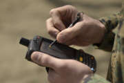 A U.S. Marine Corps civil affairs member of the Humanitarian Assistance Survey Team of Joint Support Forces Japan, uses a hand-held device to check his location using the device's GPS capabilities at Camp Sendai, Japan. The device, called a chime, is used to input and transmit data to a server where other individuals can access the information uploaded.