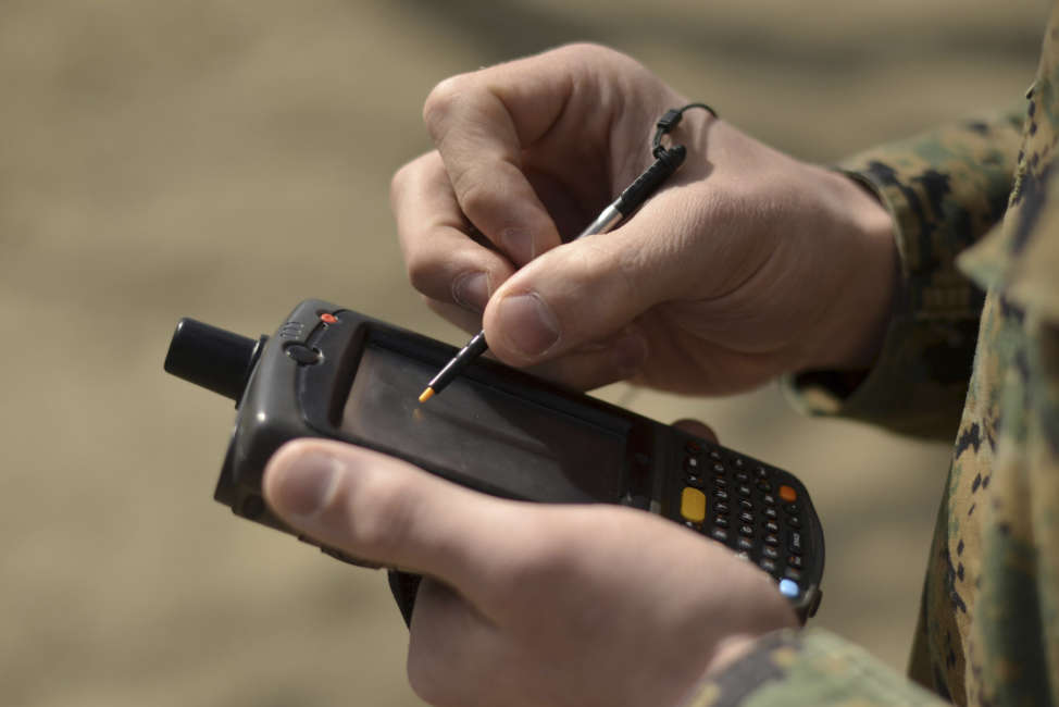 A U.S. Marine Corps civil affairs member of the Humanitarian Assistance Survey Team of Joint Support Forces Japan, uses a hand-held device to check his location using the device's GPS capabilities at Camp Sendai, Japan. The device, called a chime, is used to input and transmit data to a server where other individuals can access the information uploaded.