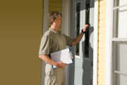 Man knocking on the front door of house doing survey, political campaign or petition signing work door-to-door.