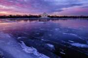 The Jefferson Memorial is reflected in the frozen surface of the Tidal Basin at daybreak in Washington, Monday, Jan 8, 2018. The Tidal Basin, famous for the Cherry Trees that surround it, is a sheet of ice after several days of bitter cold weather in the Nation's Capital. (AP Photo/J. David Ake)