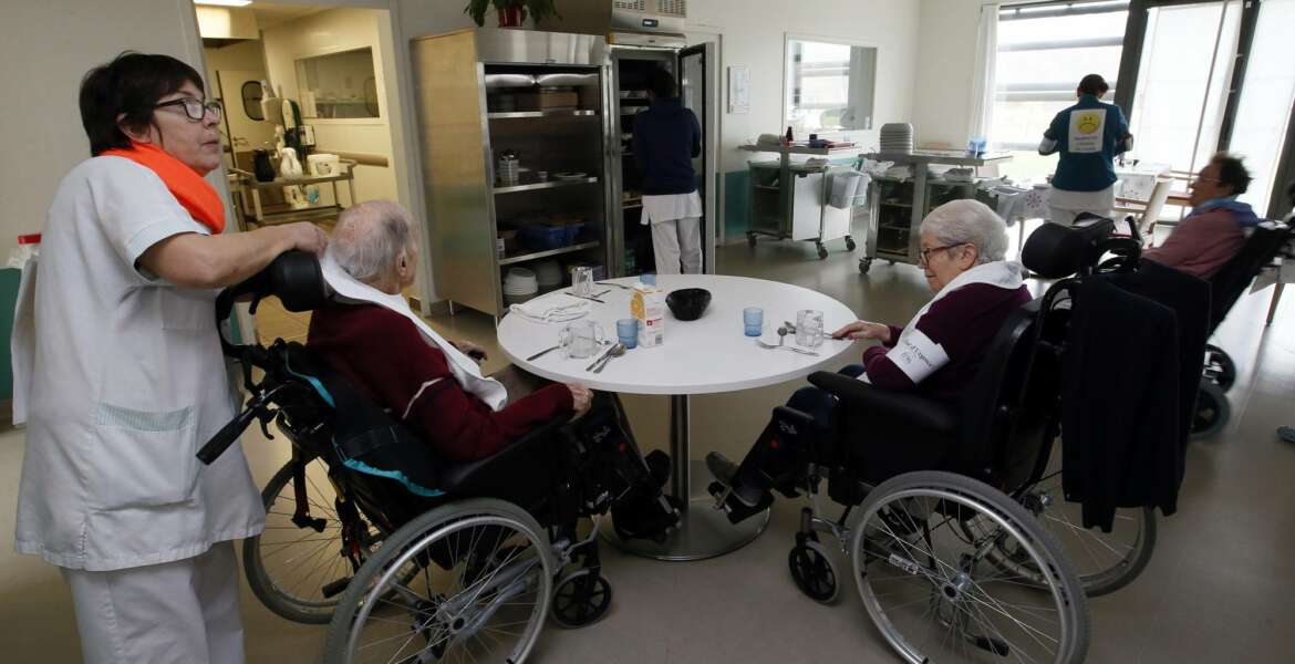 A care worker takes care to residents of the Maharin nursing home of Anglet, southwestern France, Tuesday, Jan.30, 2018. French care workers are protesting at nursing homes around the country in anger over staff shortages and cost cuts. Unions say workers are under increasing pressure to cut corners on feeding, cleaning and hygiene care for elderly residents. (AP Photo/Bob Edme)