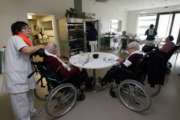 A care worker takes care to residents of the Maharin nursing home of Anglet, southwestern France, Tuesday, Jan.30, 2018. French care workers are protesting at nursing homes around the country in anger over staff shortages and cost cuts. Unions say workers are under increasing pressure to cut corners on feeding, cleaning and hygiene care for elderly residents. (AP Photo/Bob Edme)