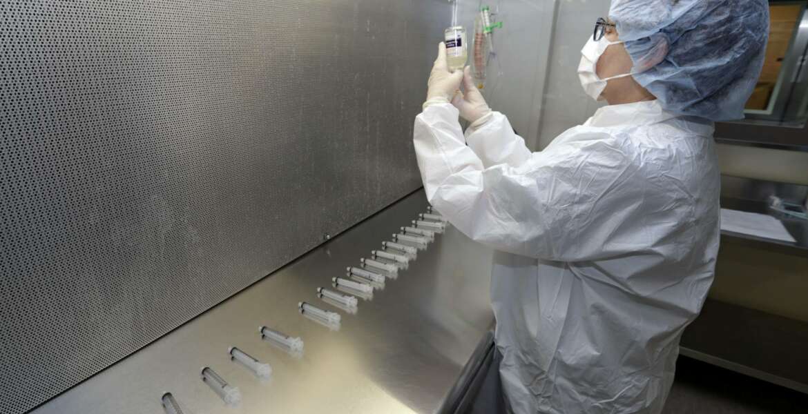In this Monday, Jan. 8, 2018, photo, certified pharmacy technician Peggy Gillespie compounds antibiotics to fill into syringes for use as an I.V. push at ProMedica Toledo Hospital in Toledo, Ohio. A nasty flu season is hitting U.S. hospitals already scrambling to maintain patient care amid severe shortages of crucial sterile fluids, particularly saline solution needed to administer I.V. medicines and rehydrate patients. (AP Photo/Tony Dejak)