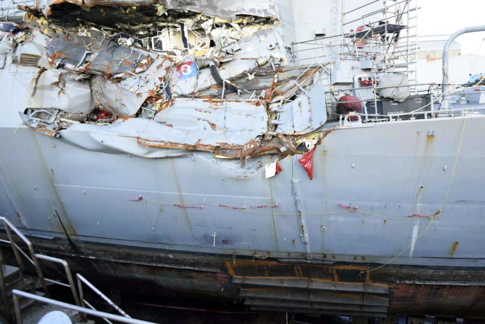 FILE - In this July 11, 2017 file photo, provided by the U.S. Navy, the USS Fitzgerald sits in dry dock in Yokosuka, Japan, to continue repairs and assess damage sustained from a June 17 collision with a cargo ship ran in the waters off of Japan. The Navy says it is filing negligent homicide charges against the commanders of two ships involved in fatal collisions last year. The charges are to be presented at what the military calls an Article 32 hearing, which will determine whether the accused are court martialed.  (Spc. 1st Class Leonard Adams/U.S. Navy via AP)