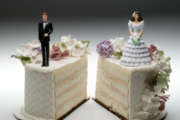 Bride and groom figurines standing on two separated slices of wedding cake