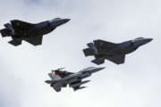 FILE - This Sept. 2, 2015 file photo shows an F-16, below, escorting two F-35 jets, above, after arriving the latter arrived at Hill Air Force Base in Utah. The U.S. and its Asia-Pacific allies are rolling out their new stealth fighter jet, a cutting-edge plane that costs about $100 million each. (AP Photo/Rick Bowmer, File)