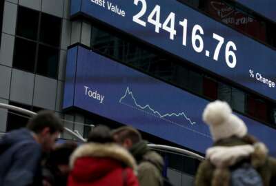 A display shows financial indices in Times Square, New York, Tuesday, Feb. 6, 2018. After big swings higher and lower, U.S. stocks are up slightly in afternoon trading Tuesday as investors look for calm after a global sell-off. The swings came one day after the steepest drop in 6 ½ years. (AP Photo/Seth Wenig)