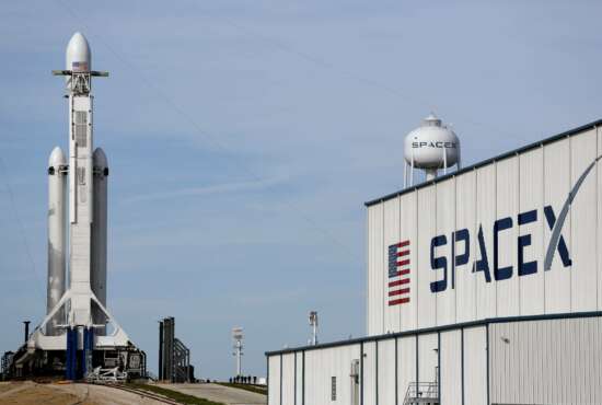 A Falcon 9 SpaceX heavy rocket stands ready for launch on pad 39A at the Kennedy Space Center in Cape Canaveral, Fla., Monday, Feb. 5, 2018. The Falcon Heavy scheduled to launch Tuesday afternoon, has three first-stage boosters, strapped together with 27 engines in all. (AP Photo/Terry Renna)