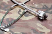 Closeup of a doctors stethoscope laying on old Military camouflage background