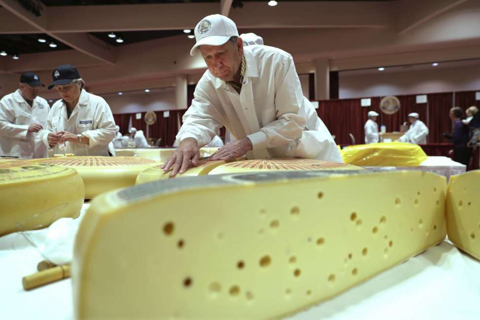 Christophe Megevand, of Schuman Cheese, New Jersey, judges the Rhined Swiss Style Cheese category in the opening day of the World Championship Cheese Contest at the Monona Terrace in Madison, Wis., Tuesday, March 6, 2018. (Steve Apps/Wisconsin State Journal via AP)