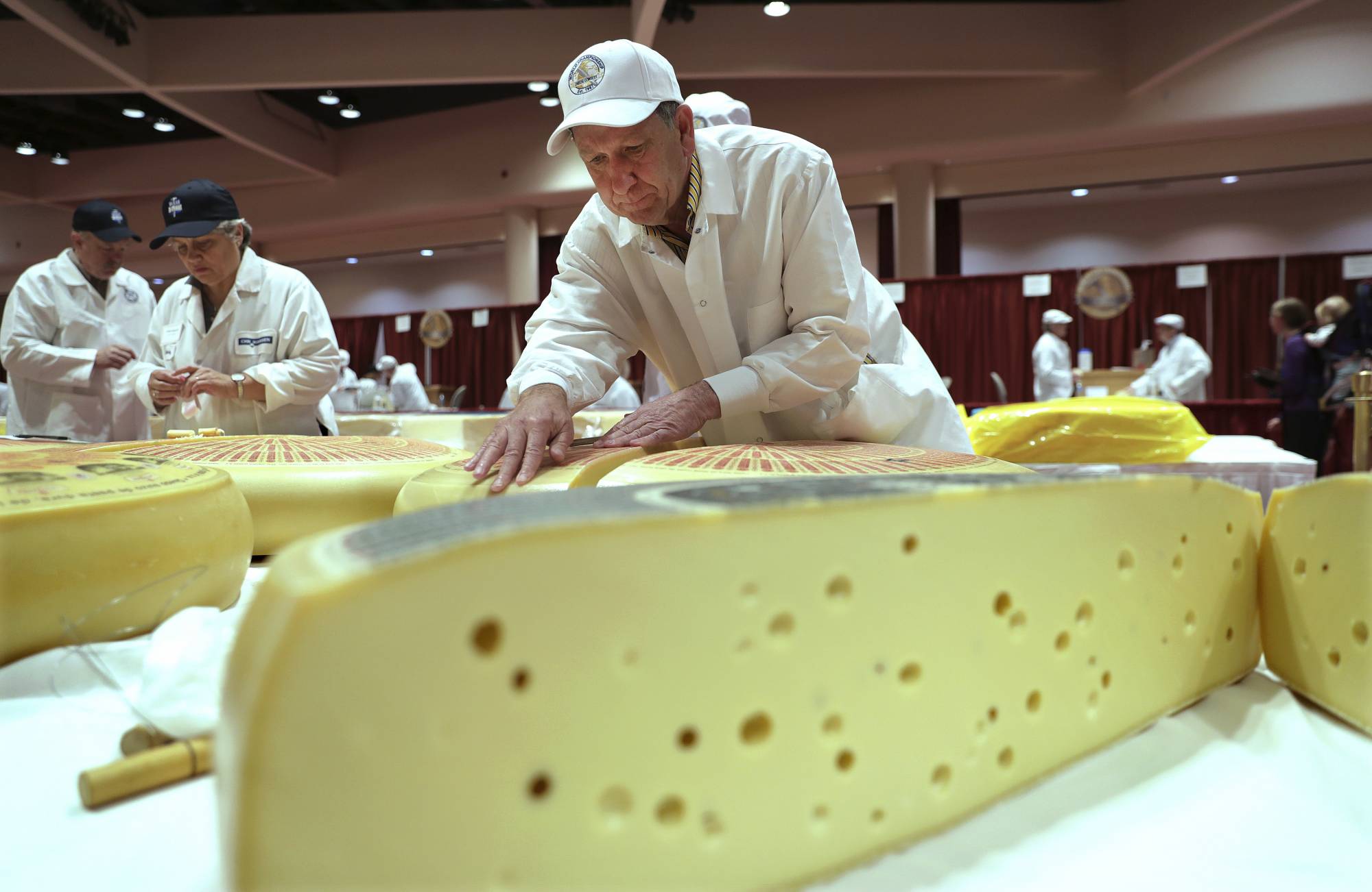 Christophe Megevand, of Schuman Cheese, New Jersey, judges the Rhined Swiss Style Cheese category in the opening day of the World Championship Cheese Contest at the Monona Terrace in Madison, Wis., Tuesday, March 6, 2018. (Steve Apps/Wisconsin State Journal via AP)
