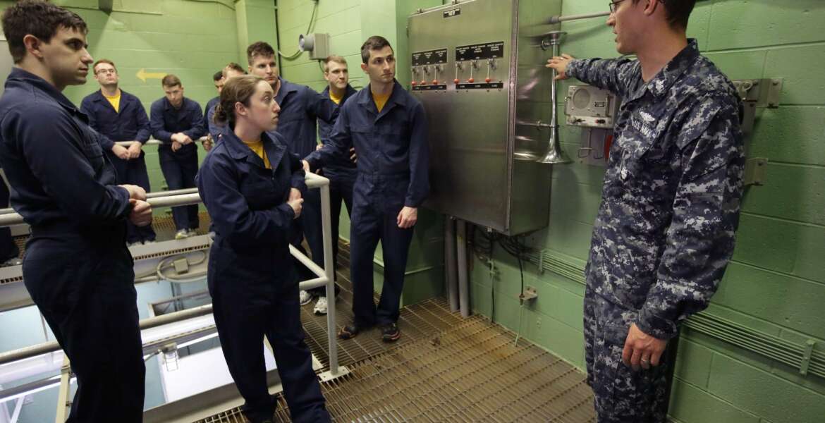 In this April 26, 2017 photo U.S. Navy Petty Officer First Class Clinton Benson, of Stanton, Mich., right, speaks to a class, including U.S. Navy Ensign Megan Stevenson, of Raymond, Maine, center left, at the Naval Submarine School, in Groton, Conn. The Navy began bringing female officers on board submarines in 2010, followed by enlisted female sailors five years later. Their retention rates are on par with those of men, according to records obtained by The Associated Press. (AP Photo/Steven Senne)
