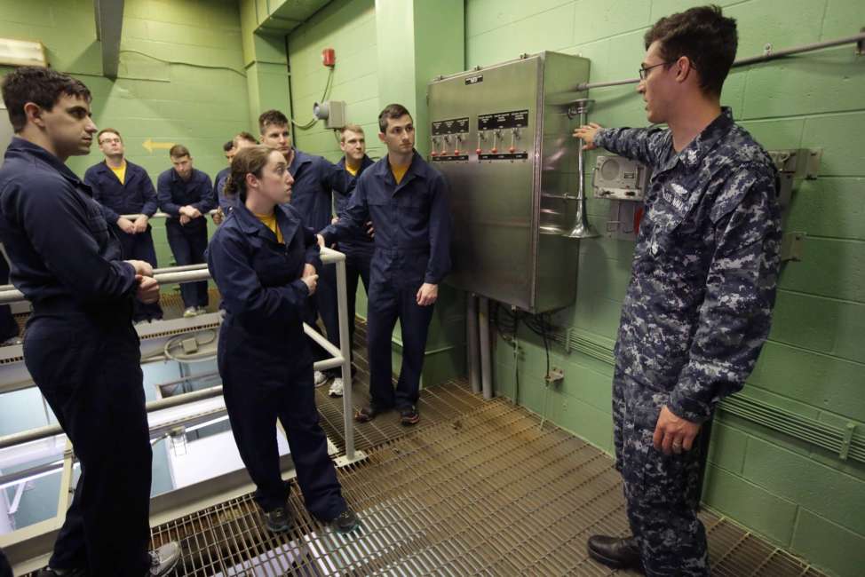 In this April 26, 2017 photo U.S. Navy Petty Officer First Class Clinton Benson, of Stanton, Mich., right, speaks to a class, including U.S. Navy Ensign Megan Stevenson, of Raymond, Maine, center left, at the Naval Submarine School, in Groton, Conn. The Navy began bringing female officers on board submarines in 2010, followed by enlisted female sailors five years later. Their retention rates are on par with those of men, according to records obtained by The Associated Press. (AP Photo/Steven Senne)