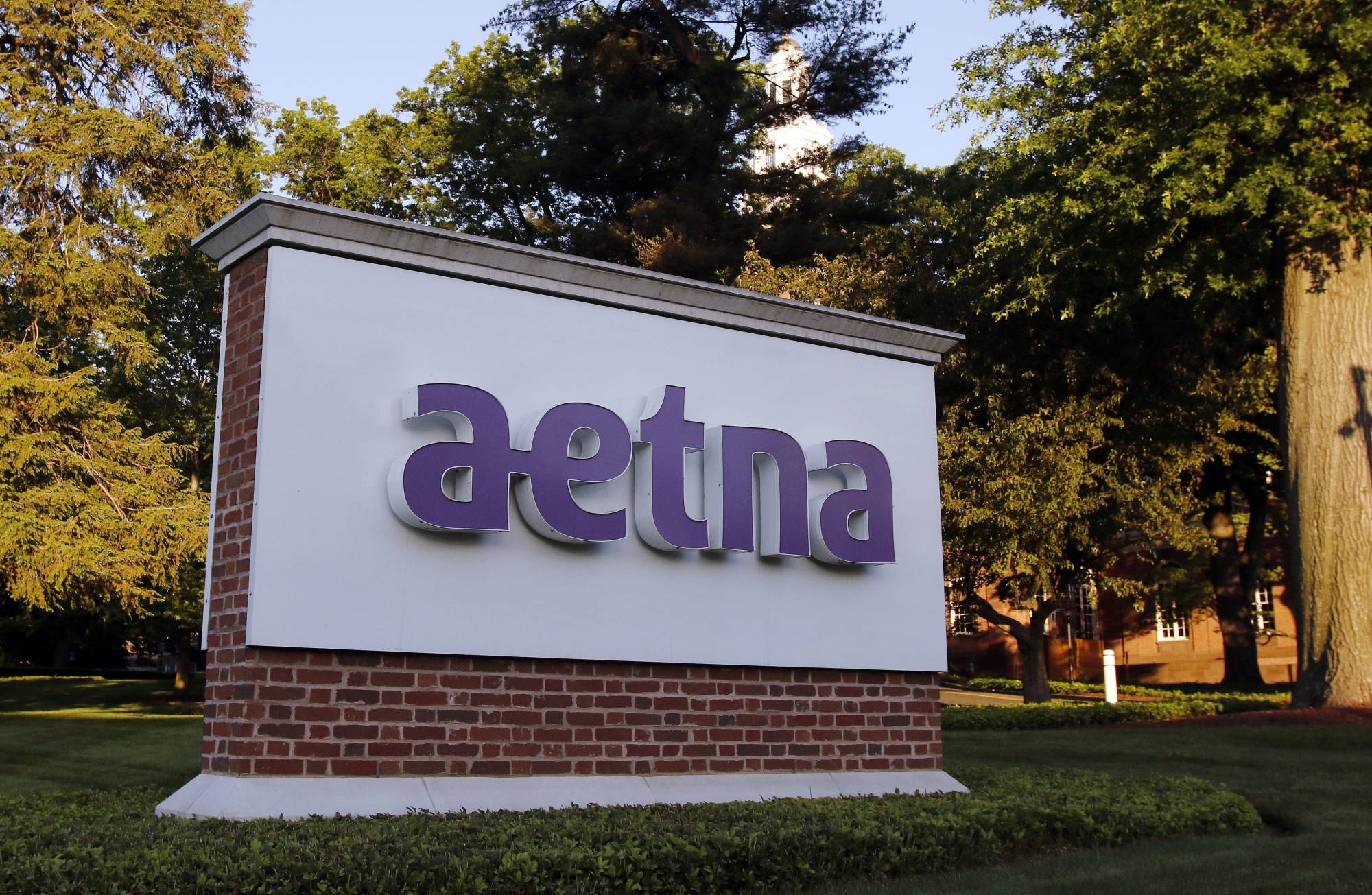 FILE - In this June 1, 2017, file photo, a sign stands on the campus of the Aetna headquarters, in Hartford, Conn. Insurers are dropping billions of dollars on acquisitions and expansions as they get more involved in their customers’ health. Late last year, CVS Health announced a roughly $69 billion deal to buy another insurer, Aetna. Those companies plan to convert drugstores into health care hotspots that people can turn to for a variety of needs in between doctor visits. (AP Photo/Bill Sikes, File)