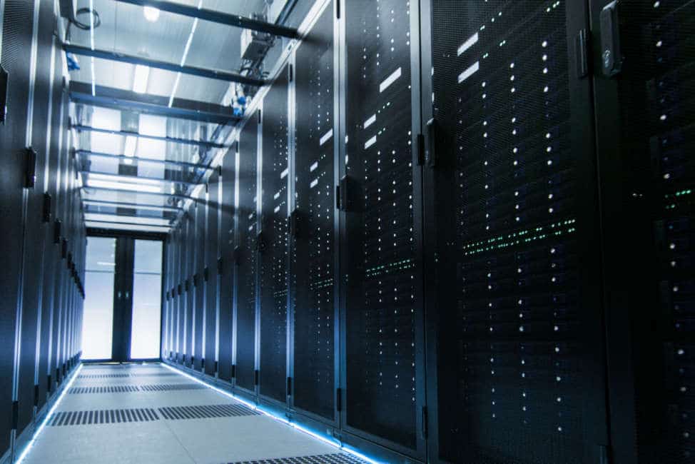 Shot of a Working Data Center With Rows of Rack Servers. People Walk and Work there, they are Blurred in Motion. Long Exposure Shot.