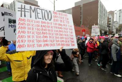 FILE - In this Saturday, Jan. 20, 2018 file photo, a marcher carries a sign with the popular Twitter hashtag #MeToo used by people speaking out against sexual harassment as she takes part in a Women's March in Seattle, on the anniversary of President Donald Trump's inauguration. Six months after bursting into the spotlight, the #MeToo movement has toppled scores of men from prominent positions and fueled a national conversation about workplace sexual harassment. Questions abound about the movement's staying power, but there's ample evidence that its impact will be durable. (AP Photo/Ted S. Warren)