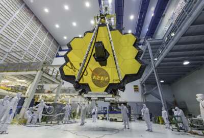 In this April 13, 2017 photo provided by NASA, technicians lift the mirror of the James Webb Space Telescope using a crane at the Goddard Space Flight Center in Greenbelt, Md. The telescope’s 18-segmented gold mirror is specially designed to capture infrared light from the first galaxies that formed in the early universe. On Tuesday, March 27, 2018, NASA announced it has delayed the launch of the next-generation space telescope until 2020. (Laura Betz/NASA via AP)