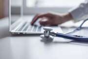 Doctor working with laptop computer in medical workspace office. Focus on stethoscope