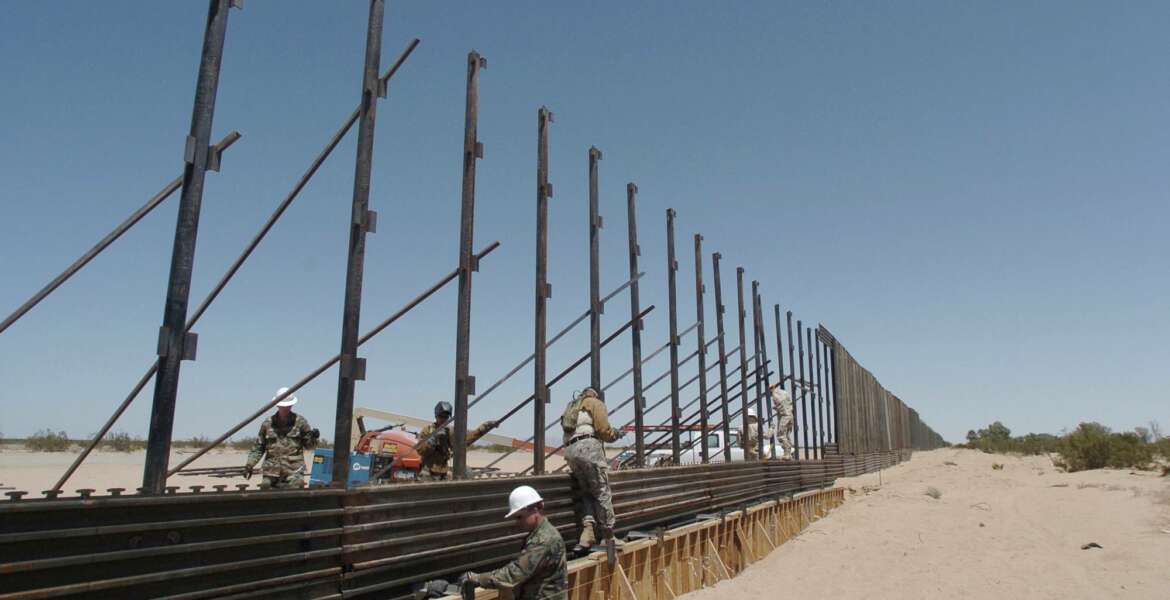 FILE - In this June 8, 2006, file photo, members of the National Guard work on construction of a border wall at the U.S.-Mexico border next to San Luis Rio Colorado, Mexico. Photo was taken from a few steps into the United States. The arrival of U.S. National Guard troops in Arizona has scared off illegal Mexican migrants along the border as a whole, significantly reducing crossings, according to U.S. and Mexican officials. From 2006 to 2008, the Guard fixed vehicles, maintained roads, repaired fences and performed ground surveillance. (AP Photo/David Maung, File)